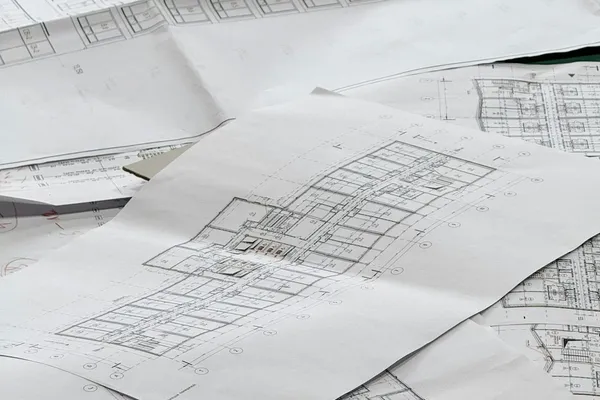 Engineering blueprints spread on a table for a septic system design